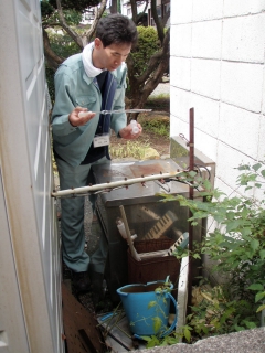 蚊の幼虫(ボウフラ)を採取するセンター職員の写真