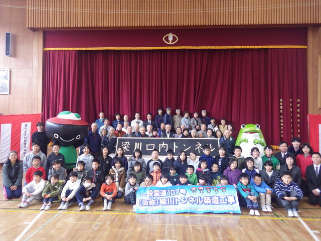 起点(奥州市)側坑口部のトンネル銘板を囲んで記念写真(奥州市立梁川小学校)の状況