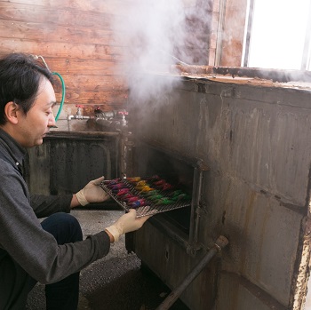 釜入れをする高橋一行さんの写真