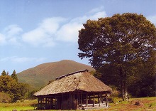 一関市千厩町奥玉から見るケヤキの木と茅葺きの建物と室根山の景観